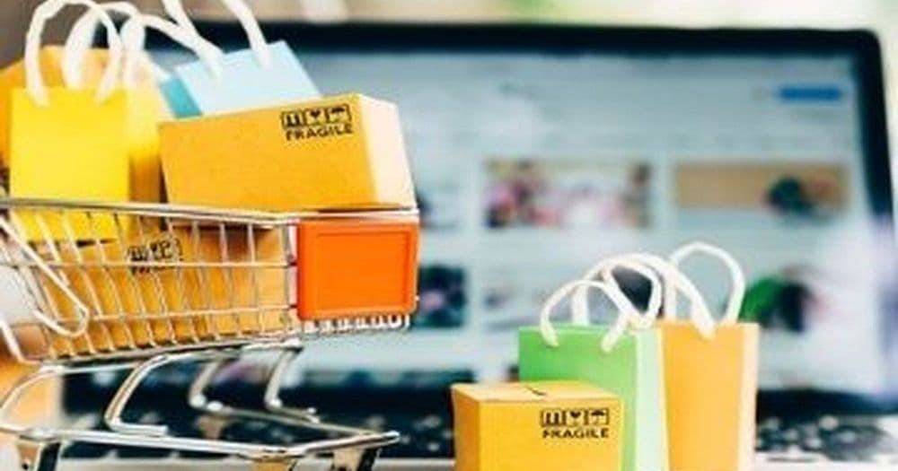 Shopping cart and gift bags in front of an online store on a laptop